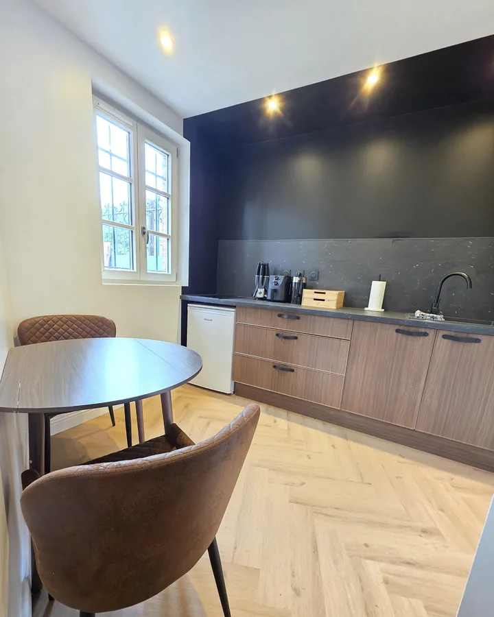 Cuisine et coin repas d’un logement géré par One Call Conciergerie, parquet à chevrons